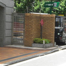 路地を少し入りますと、左側に、赤色の標識が立てられています。