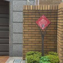 泉鏡花旧居跡の標識が、壁の横に立てられています。