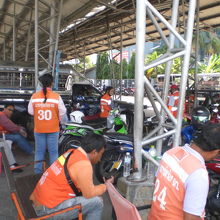 多数のバイクタクシーのドライバーが集まり、乗客を待っています