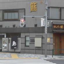 寿司店の壁の解説板は、多くの広告の中で、あまり目立ちません。