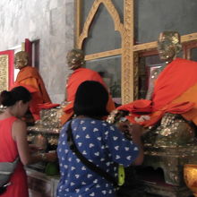 本堂で金箔をブロンズ像に貼り付けます