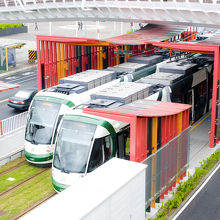 緑の車両とレール、そして赤の駅舎