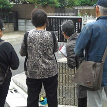 研修者が、泉鏡花旧居跡の解説板を見ながら、話し合っています。