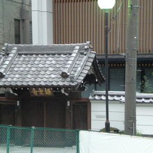 道路から見た、伝統的な格調の高い山門と背景の近代的な本堂です