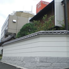 緑雲寺の伝統的な山門と塀の後方に、近代的な本堂があります。