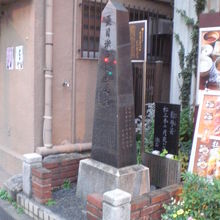 夏目漱石の誕生の地の石碑、句碑、解説を、右側から見ています。