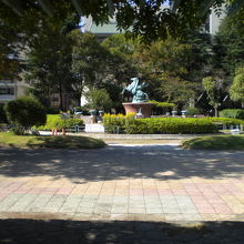 赤羽公園の中央に、淡青色の噴水のような施設が見えます。