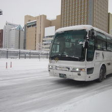 シーズン初雪道の中、大幅に遅れて到着したバスの様子