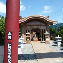 黒が濃いえんじ色の鳥居の奥の社殿