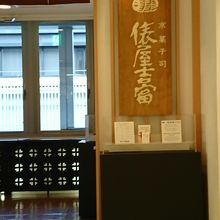 店舗入口の看板（入口前には百貨店のエレベーターがあります）