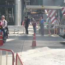 バイクタクシーの利用者が列を作り、順番に乗車し、出発していま