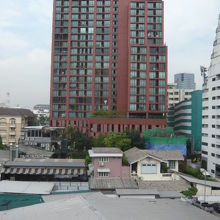 緑の樹木、青い青壁のビルの中に、鮮やかに聳える赤色のビルです