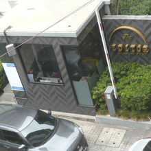 高級コンドミニアムの出入口を通過する車両と警備所の様子です。