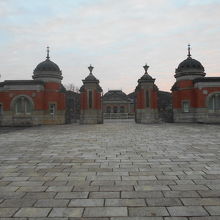 なだらかに上がる石畳の先の正門、その奥の煉瓦建て建物が現存