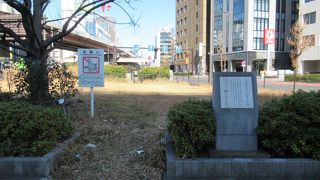 説明板付の石碑が交差点脇の広場の歩道沿いにあるのみです