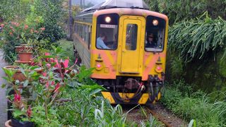 鄙びた景色の中を走るオレンジ色の列車