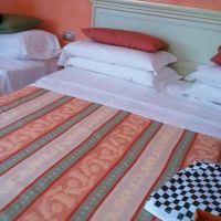 ベネチアンガラスのシャンデリアがあるシングルベッド３台の部屋