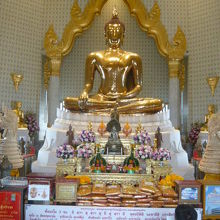 黄金仏の祭壇の前には、信者が供えた供物が多く置かれています。