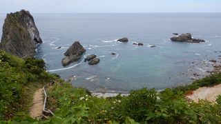 日本の渚１００選。海の深い青と、黄金色の岩肌のコントラストが美しい