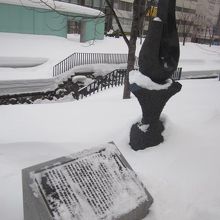 札幌建設の地碑と、軽く雪没した解説板の様子