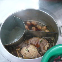 屋台の中央に麺のスープと、麺に入れる具を温めている様子です。