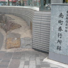 南町奉行所跡の標識の横には、昔の石垣と解説板があります。