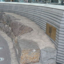 南町奉行所跡の標識の横には、長い石垣と解説板が見られます。