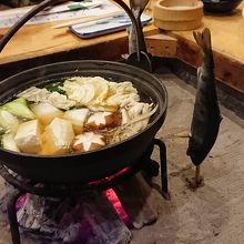 囲炉裏端での夕食の鶏鍋。そばで、アマゴを焼いています。