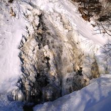 凍り付いた滝の一部に水が流れている
