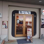 店名の看板には猫が笑顔で魚をくわえている。地魚どんぶりでおなかいっぱい