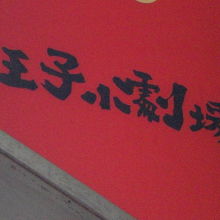 花まる学習会王子小劇場の入口に掲げられた赤色の標識です。