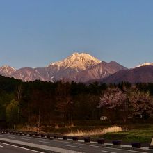 入口の道路から朝焼けの常念岳