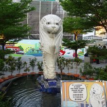 バックに、幕で覆われた本家のマーライオンが