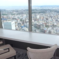 窓際に広いテーブルと椅子があります。