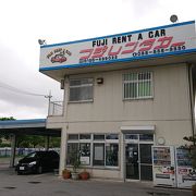 沖縄セルラースタジアム那覇の手前にあるレンタカー店です。那覇空港から予約したお客用のバスがでる。給油省略、保険付き等のサービス付きも良し。