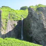 壮大なスケールの遥か崖上で白糸を引く滝