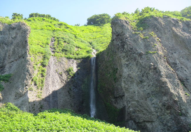壮大なスケールの遥か崖上で白糸を引く滝