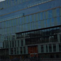 ガラス張り大型ビルの一角に入居、壁面にホテル名の標識あり