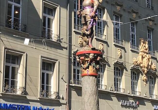 兵士の足元にいる子グマが銃を持って