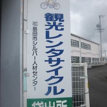 駐輪場の脇に見られるレンタサイクル看板の様子