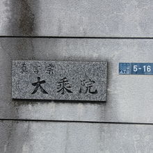 コンクリートの塀に寺名標が