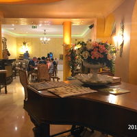 グランドピアノのあるロビー、奥は食堂