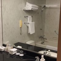洗面台と(鏡に映る)バスタブ・シャワー 