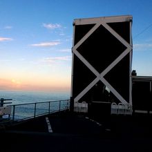 駐車場から店の入口と海を眺める