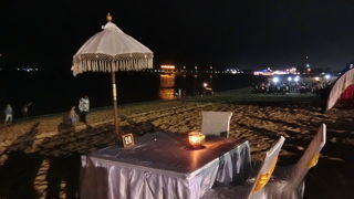 ビーチの砂浜にずらりと並んだテーブルとイス、シーフードディナー、トウモロコシ屋台