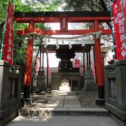 石造りの玉垣に囲われ数多くの朱い幟が目立っている稲荷神社です
