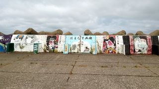 防波堤に描かれた約256点ものにぎやかな絵画展、津波慰霊碑も