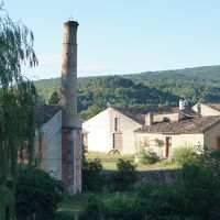 庭からラヴェンダー農家のオイル蒸留の煙突のある建物