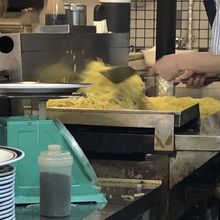 スタッフが大量の麺を炒めている