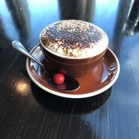 レストランのカプチーノ。赤い丸いのは、チョコです。